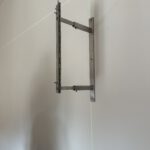 Bildhalterung aus Edelstahl für ein Zweiteiliges Gemälde über zwei Wände hinweg.
