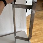 Bildhalterung aus Edelstahl für ein Zweiteiliges Gemälde über zwei Wände hinweg.