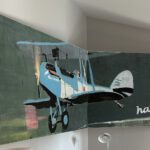Bildhalterung aus Edelstahl für ein Zweiteiliges Gemälde über zwei Wände hinweg.